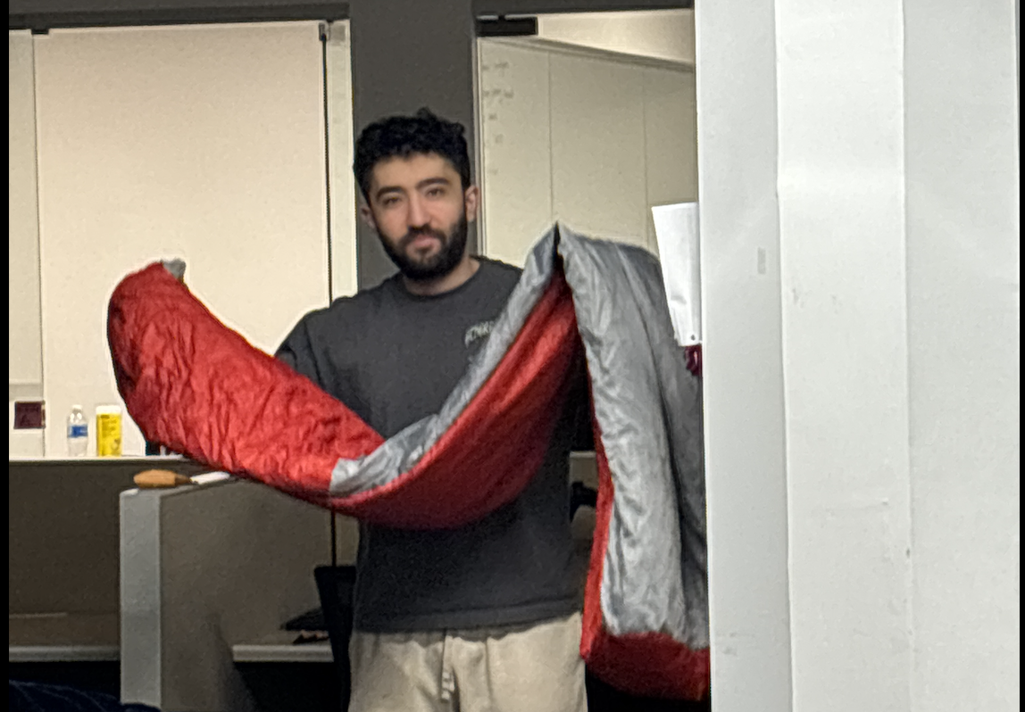 Founder holding a sleeping bag in the Althra office.